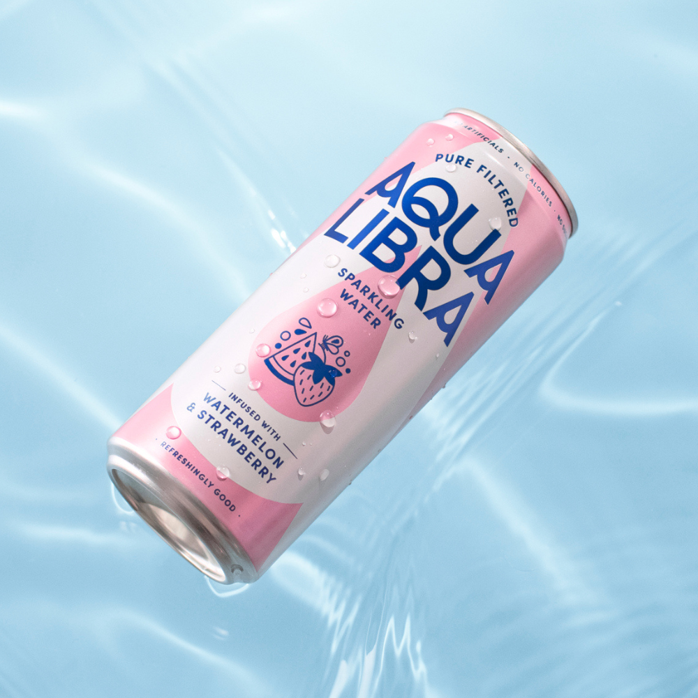 Aqua Libra sparkling water can with watermelon and strawberry flavor on a light blue background